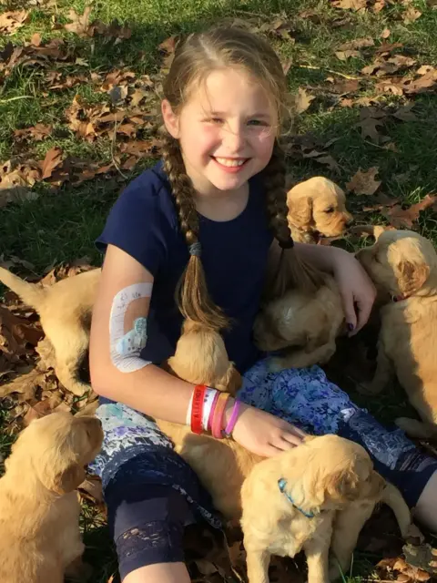 Our daughter holding and playing with one of our first litters of Goldendoodles
