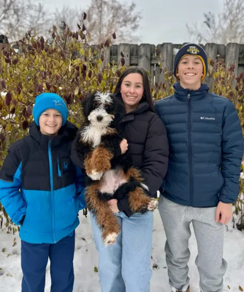 New brothers and sister of a Happy Bernedoodle being picked up and going home.