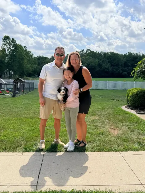 A family of three adopting a puppy to make it four.