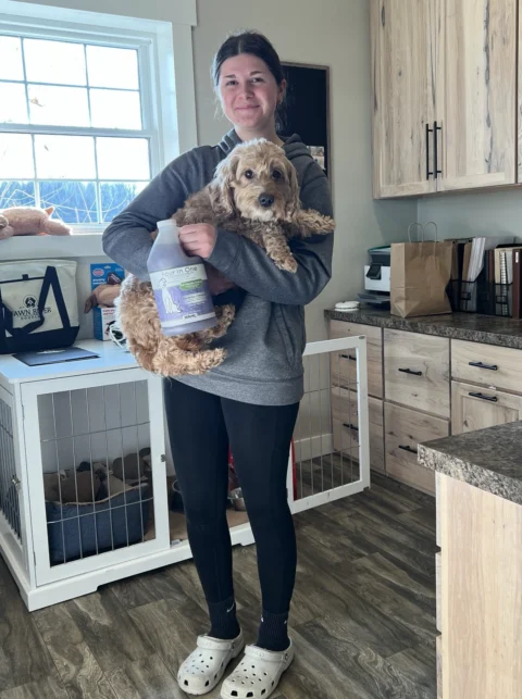 FRD showing Wahl's shampoo while holding Goldendoodle