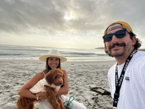 Happy family with their goldendoodle on the beach