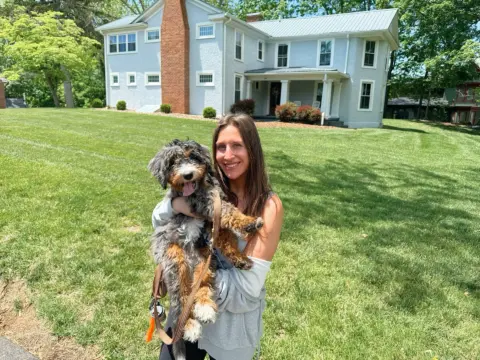 Mom and her Bernedoodle taking a family pictures.