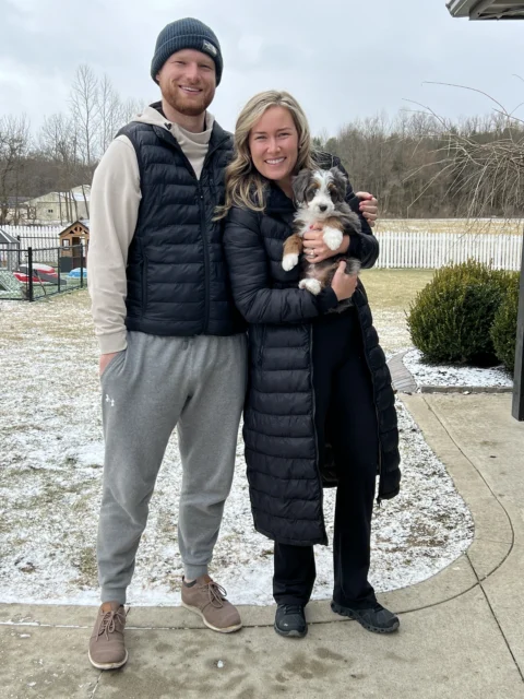 Happy owners going home with their new Bernedoodle