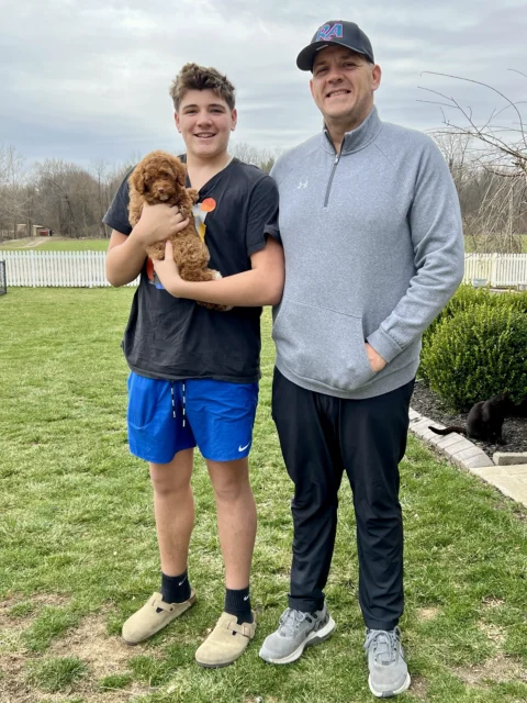 Dad and Son picking up their new Goldendoodle