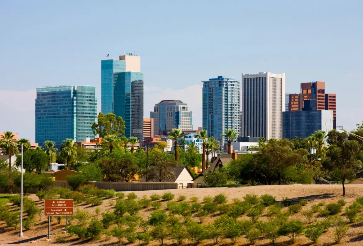 Downtown Phoenix skyline with high rises, palm trees, and desert landscape.